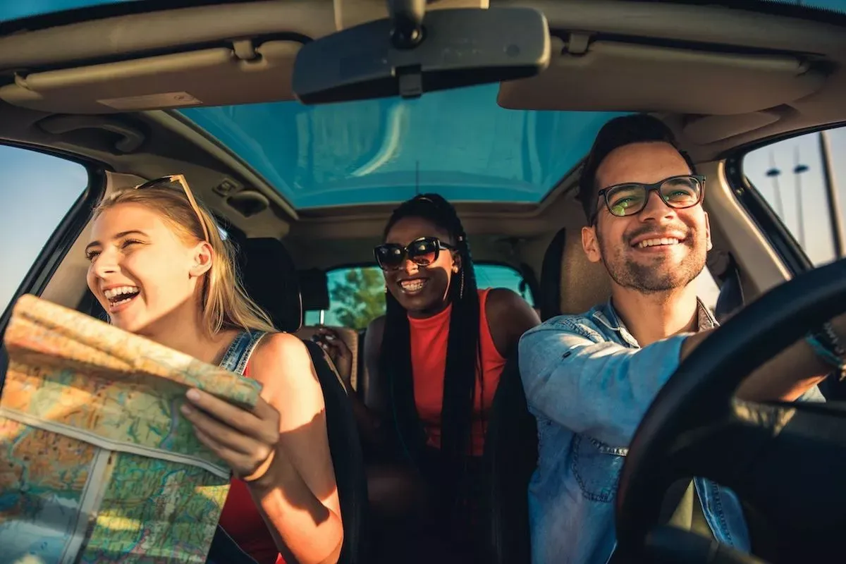 Three smiling people in a car